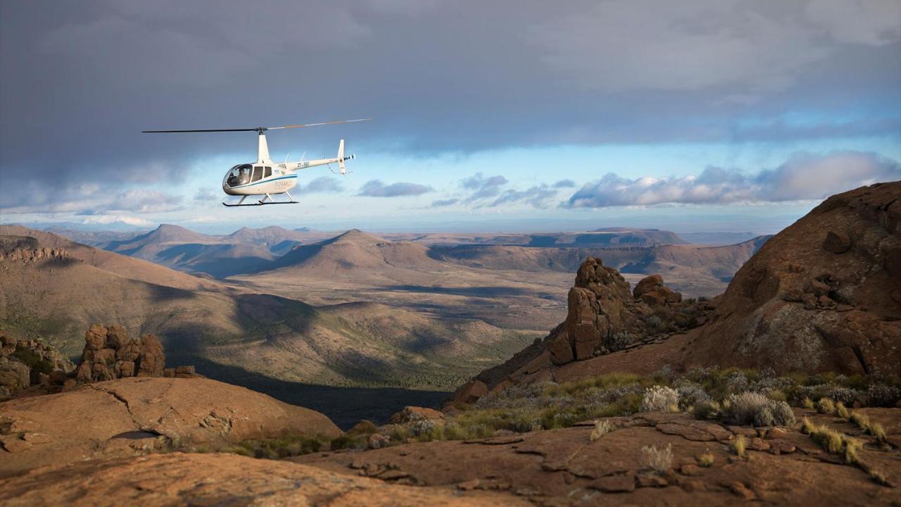 Drostdy Hotel Graaff-Reinet Exteriör bild A Robinson R44 helicopter flying over the Namib Desert